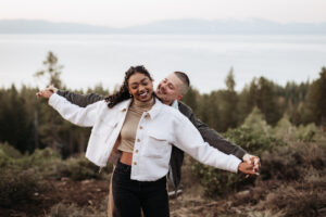 Fiancé holds his partner's hands for a joyful sunrise engagement photo in Lake Tahoe