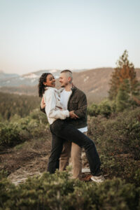 A soft pink sunrise creates a magical backdrop for a Lake Tahoe engagement session