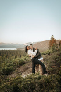 Lake Tahoe’s sunrise casts dreamy colors over an engaged couple on a mountain