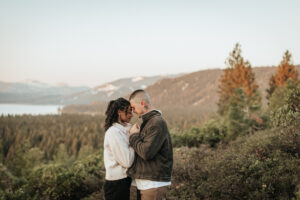 Epic mountaintop engagement photo in Lake Tahoe with golden morning light