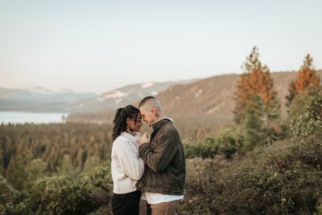 A soft pink sunrise creates a magical backdrop for a Lake Tahoe engagement session